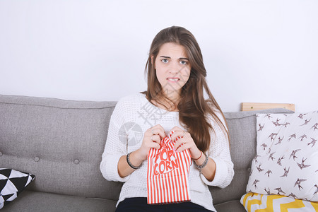 女人在沙发上看电影吃爆米花图片