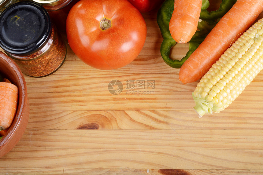 在木制桌上做饭的蔬菜和调味料图片
