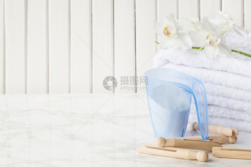 用洗涤剂一堆白色毛巾木板和白兰花用蓝色塑胶水杯一叠白色毛巾木板和白兰花在木板的白色底面大理石表图片