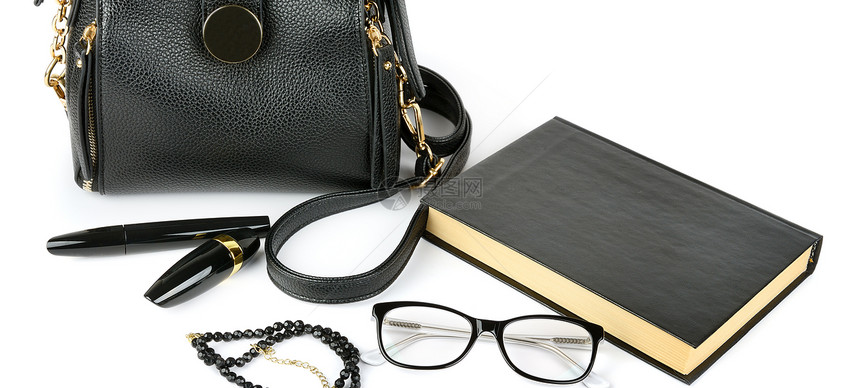 白色背景中的皮包眼镜书化妆品和首饰图片