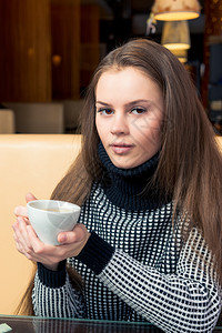 黑毛衣咖啡厅里喝着茶的黑头发可爱黑美女图片