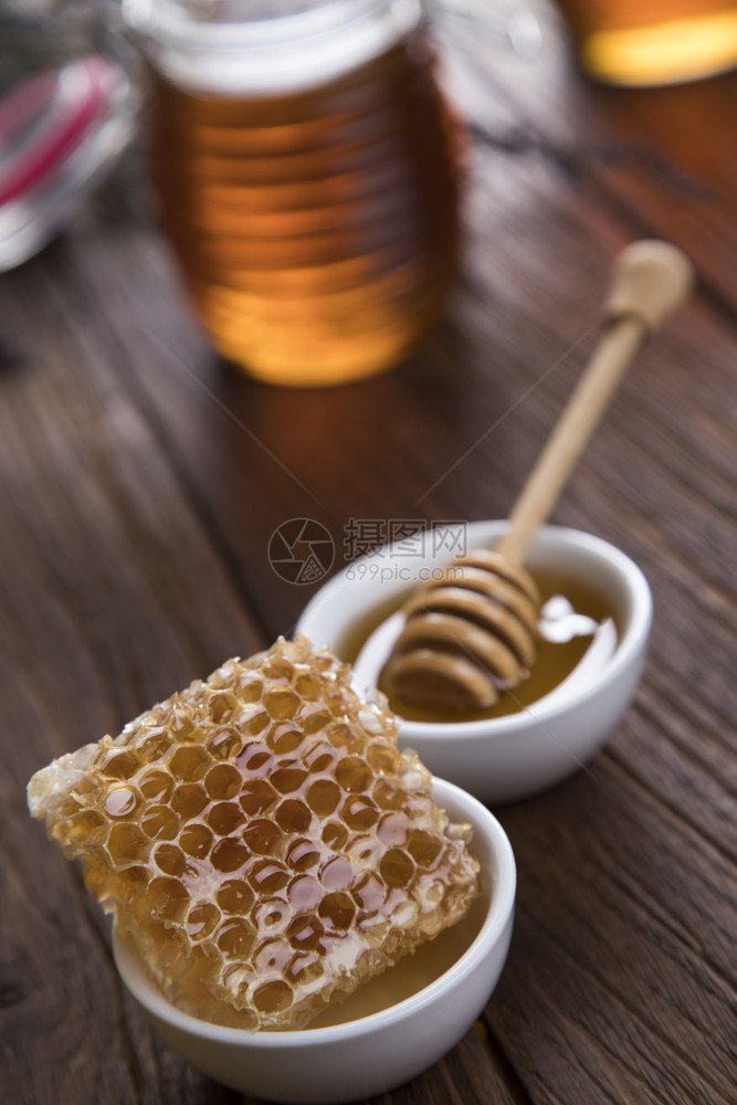 在梳子中甜的蜂蜜加一罐和窝的图片