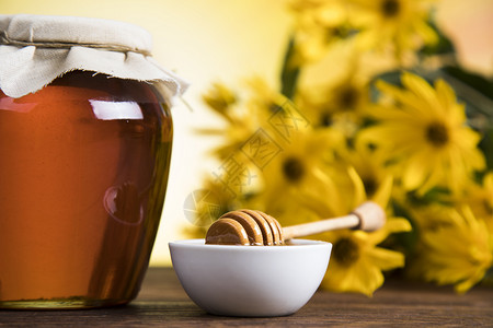 蜂蜜在罐子中的花朵甜的蜂蜜高清图片