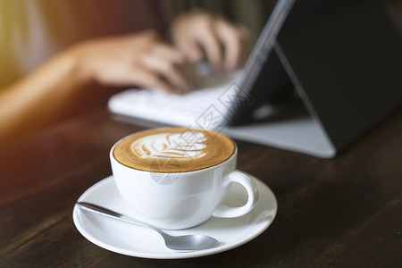拿铁锹的人以阳光生活方式概念在咖啡厅的平板电脑上打字背景