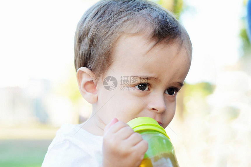 在公园里喝奶瓶的男孩图片