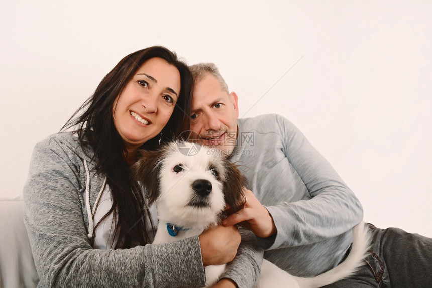 夫妇在室内抱着小狗图片