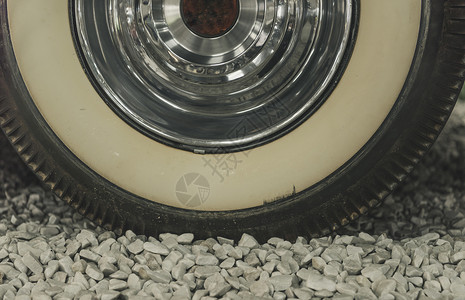 阿斯顿子边缘和旧车轮的子胎和闪亮的铬子细节背景