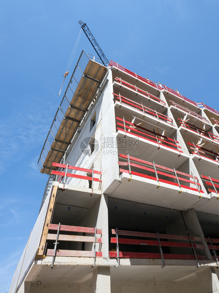 建筑工地有混凝土结构以及蓝色天空下出于安全原因的红木板图片