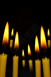 黄蜡烛在抽象的黑暗背景上图片