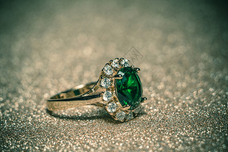 山川绿宝石戒指优雅的女首饰金环珍贵的绿宝石过滤背景背景