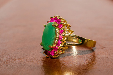 金色绿宝石戒指优雅的女首饰金戒指配有珍贵的绿宝石背景