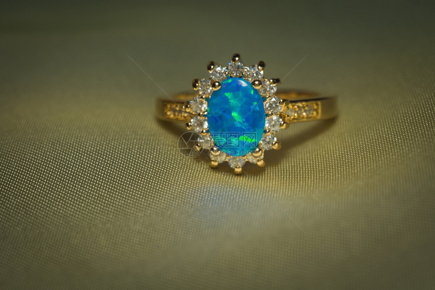装饰着蓝火花宝石的金色戒指图片