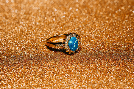 装饰着蓝火花宝石的金色戒指图片