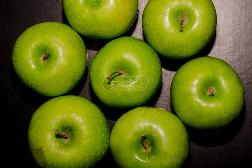 堆满成熟的绿苹果关闭背景图片