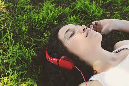 美女在草地上听音乐图片