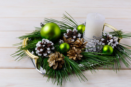 带有银色雪和漂白松果的圣诞中环节背景餐桌上有蜡烛和装饰品复制空间图片