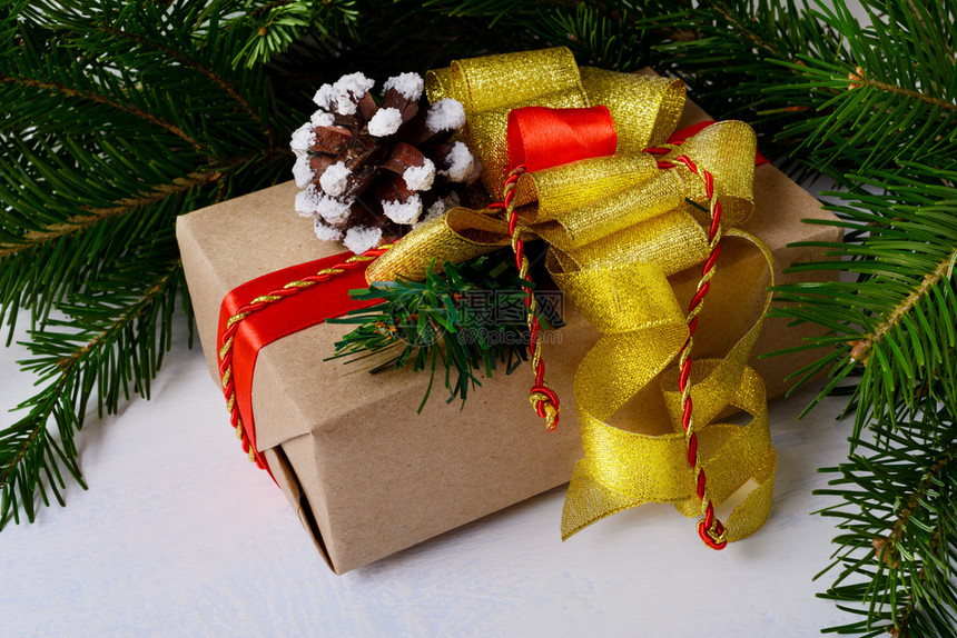 圣诞礼物盒配有金弓和雪松锥图片
