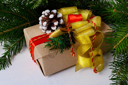 红色雪松丝带圣诞礼物盒配有金弓和雪松锥背景