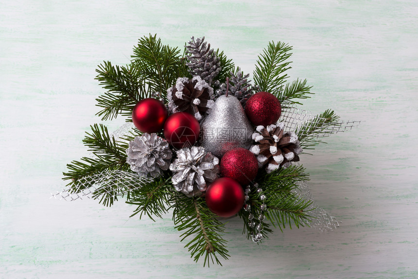 圣诞花环有银光亮的梨子和红装饰品圣诞节桌中心有松果图片