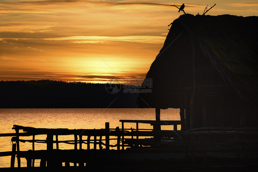 令人惊叹的日落风景上面有个木屋和一只鸟在湖边金色时段在波德森湖图片