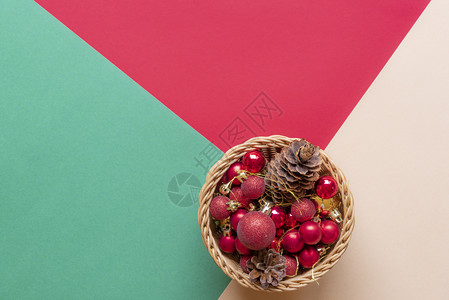 许多红色的圣诞地球和一对松果在木棍篮子上图片