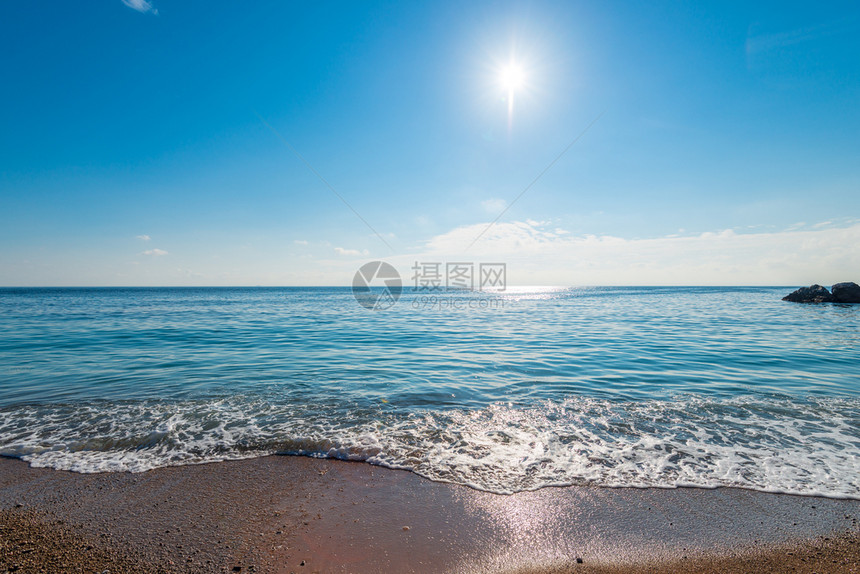 蓝色的海水和在地平线上照耀的阳光图片