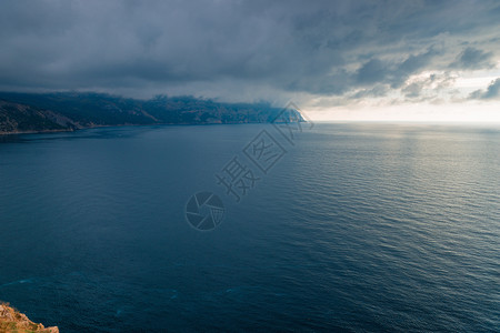 暴风雨前的自然黑云宁静的海面上背景图片
