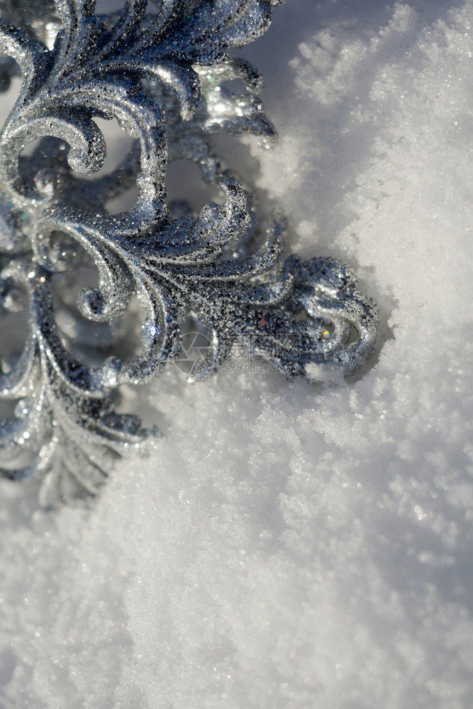 装饰银雪花闪发光亮于新鲜的白雪上图片