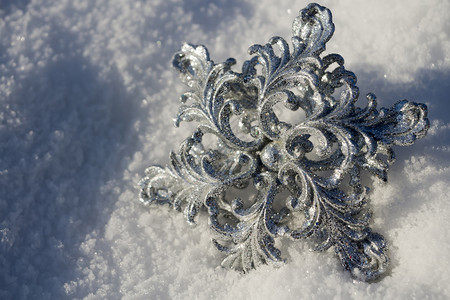 装饰银雪花闪发光亮于新鲜的白雪上图片