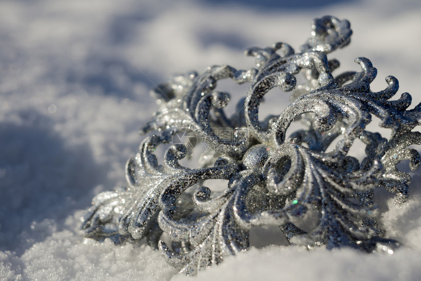 装饰银雪花闪发光亮于新鲜的白雪上图片