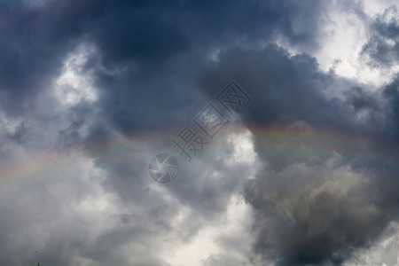 彩虹多与阴暗的云背景相对照背景图片
