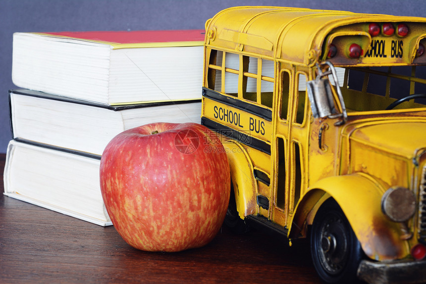 提供书籍苹果蜡笔和学生公共汽车的校用品图片