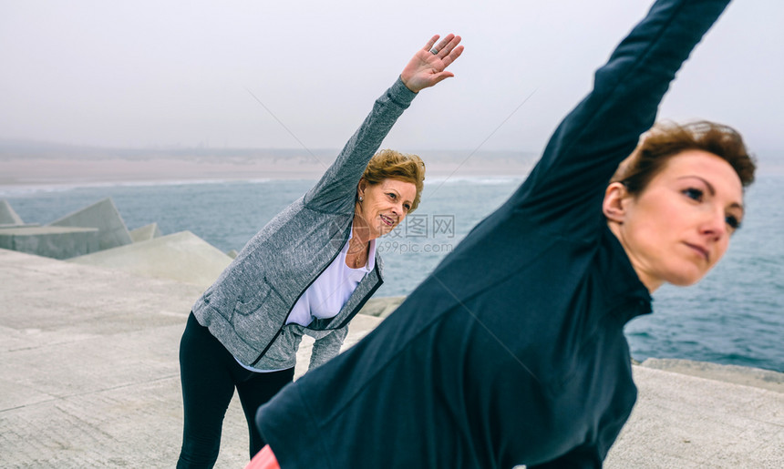 高级女与教练在海码头一边有选择地关注背景中的女高级与教练一边有选择地关注背景中的女图片