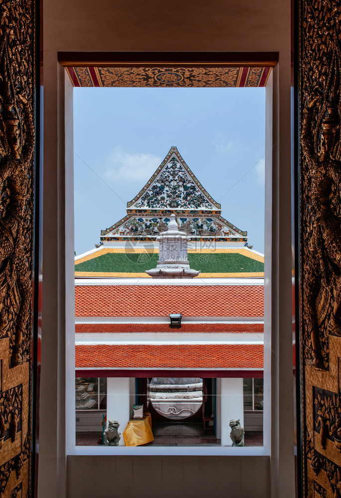 寺庙瓷砖屋顶和风格的外观通过thonburi区皇室寺庙hangkowatrchosm的窗户看到图片