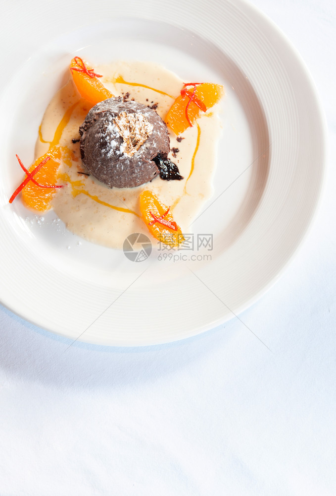法国甜点巧克力味熔岩蛋糕香草酱柑橘和金叶图片
