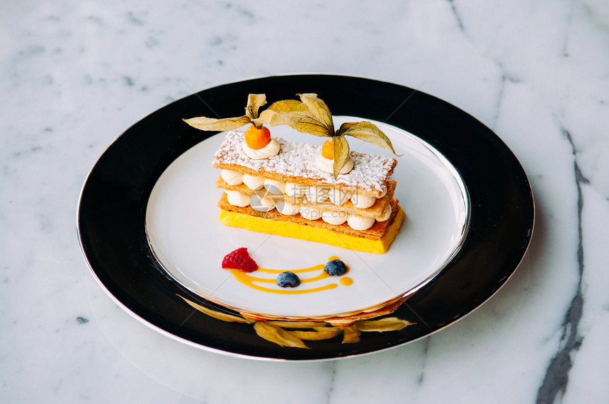 美味的芒果菜浆磨油美式大理石桌上的优雅盘子法国口味糕饼图片