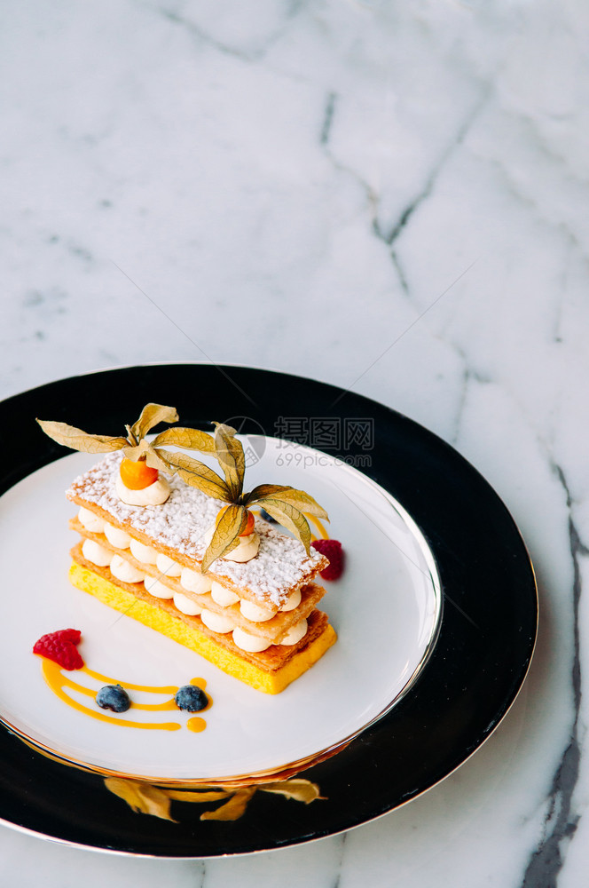 美味的芒果菜浆磨油美式大理石桌上的优雅盘子法国口味糕饼图片