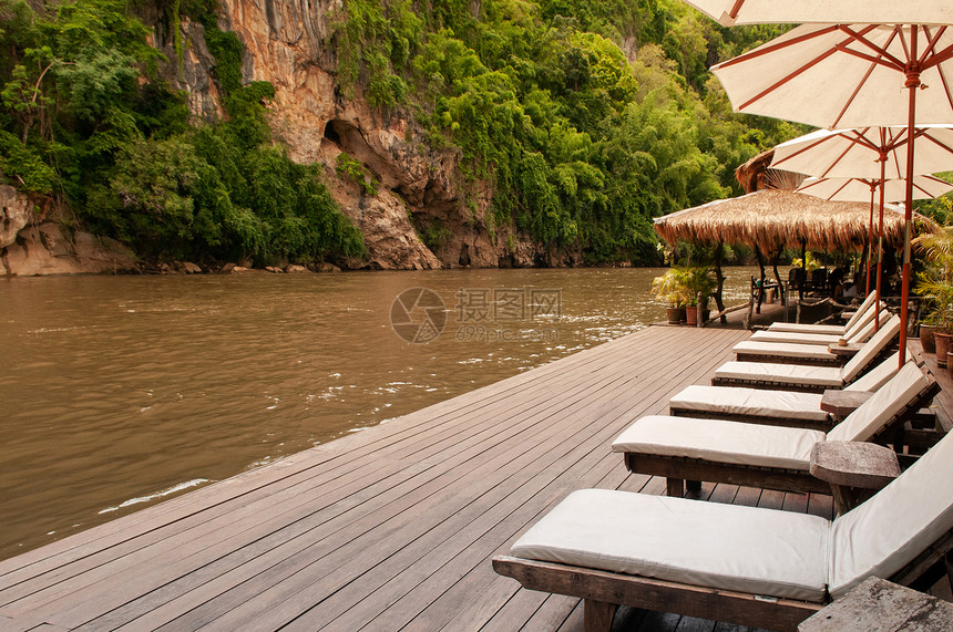 Kwai河knchburi河Thalnd河边的沙滩床和白色雨伞图片