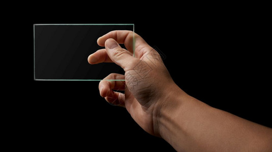 人手在文字的黑色背景位置上握着透明玻璃手握透明玻璃背景图片