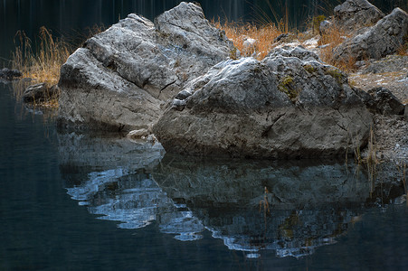 在伊布西湖巴伐利亚德意志等地的一帮石头和橙草及其水反射的近距离图像图片