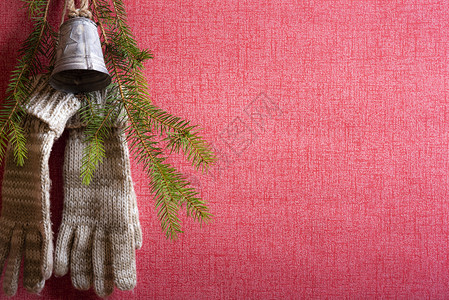用钉子挂在红墙上的手套挂在红墙上还有松树枝和圣诞钟图片