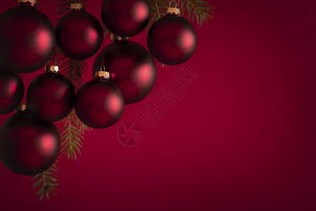 圣诞节横幅上挂着毛发红球在树枝上红色模糊的背景适合贺卡或圣诞节背景图片