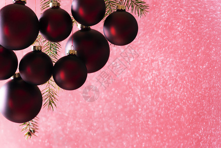 深红色的圣诞优雅的深红色圣诞球在下雪时挂着从喷雾中在明亮的光线下完美地用于圣诞节贺卡或旗帜背景