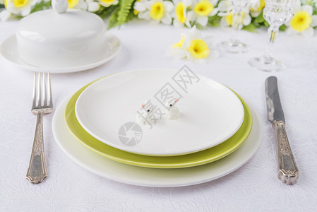 东边晚宴的经典白绿色瓷板银器白桌布上的春花图片
