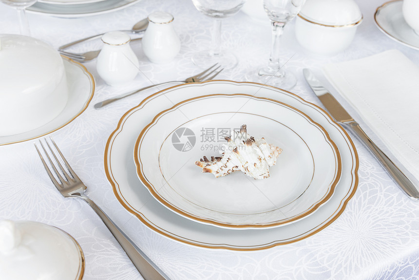美的装饰桌白色板眼镜餐具和豪华桌布上的海壳图片