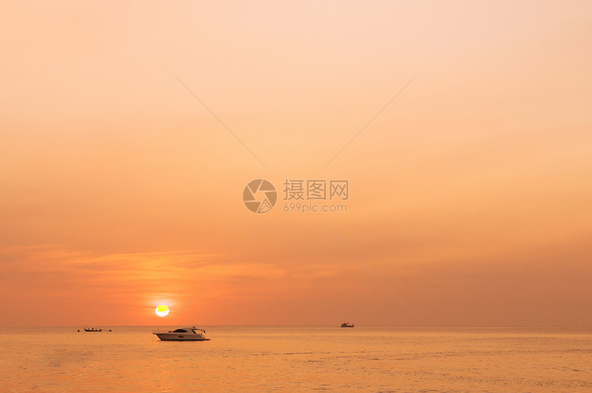 金色的日落与月光般的船停在海边的普吉岛图片