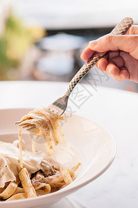 鸡肉面粉和松露的意大利面白理石桌上有叉子的侧面图片