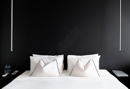 黑水泥墙白色床的卧室和侧桌灯具背景图片