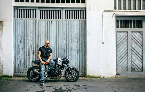 摩托车手在库门前摆着一辆定制摩托车手在库门前摆着一辆摩托车图片