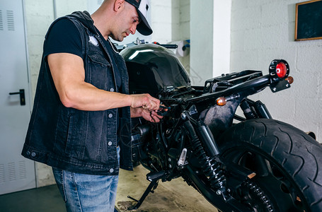 技工在车间更换保险丝修理定做的摩托车摩托车修理工换保险丝图片